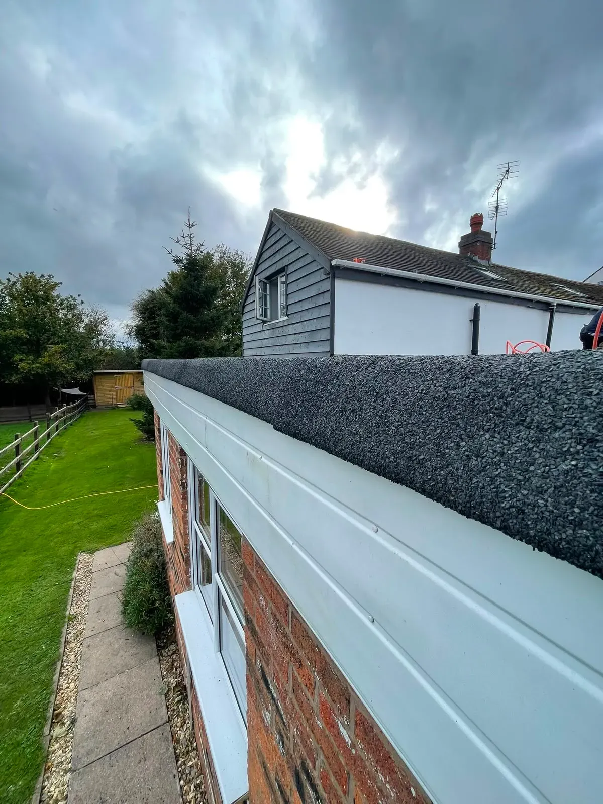 Mineral felt flat roof edging with white UPVC fascia installed on a residential extension