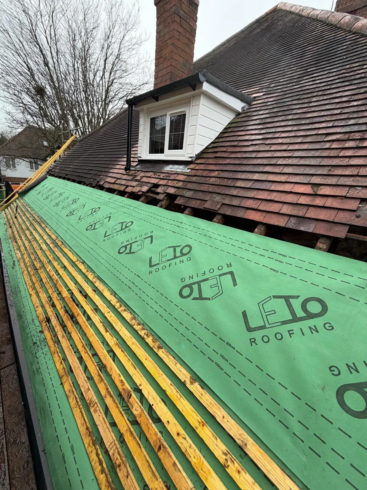 Breathable membrane underlay and timber battens being fitted during pitched clay tile roof repairs in Worcestershire