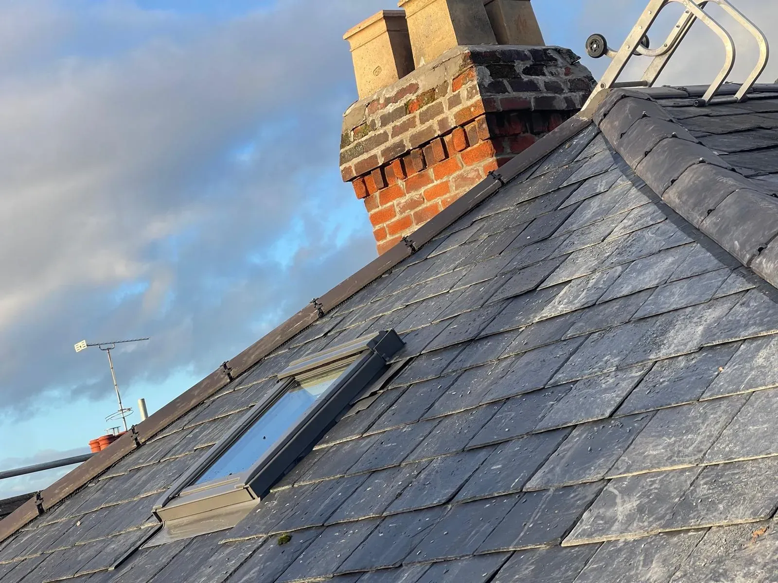 Natural slate roof with skylight and traditional brick chimney stack in Worcester