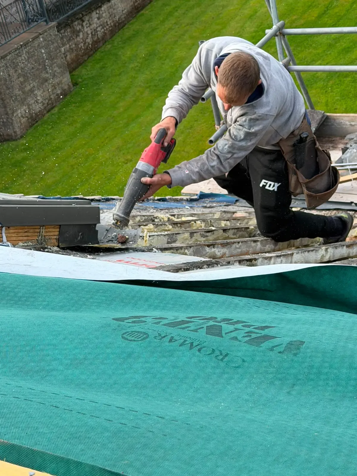 Roofer trimming timber battens and installing breathable underlay membrane during a pitched roof renovation in Worcester