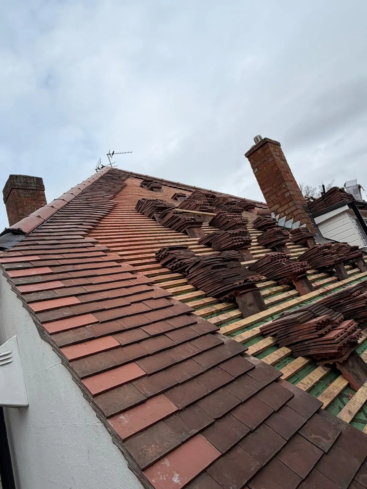 Pitched roof tile installation with plain clay tiles stacked on timber battens in Worcester