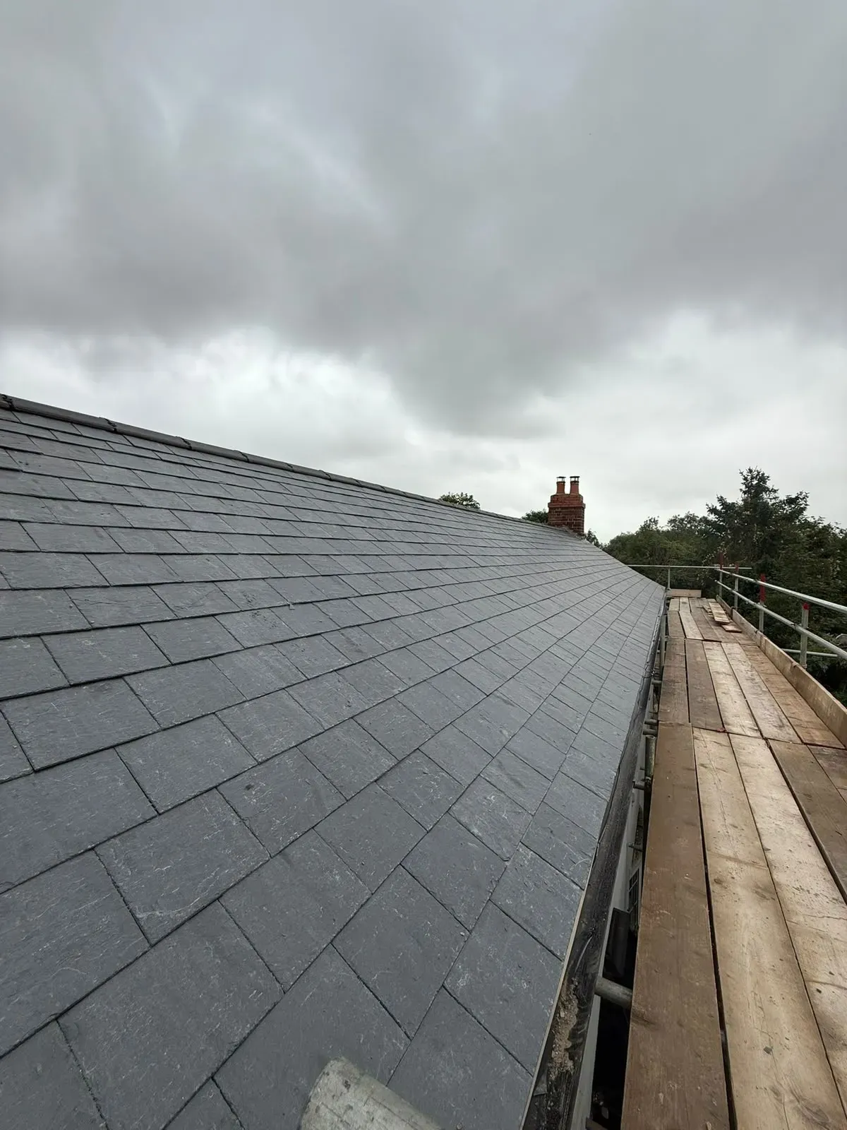 Newly installed pitched slate roof with ridge tiles and scaffolding by STORMPROOF ROOFING & REPAIRS LTD in Worcester