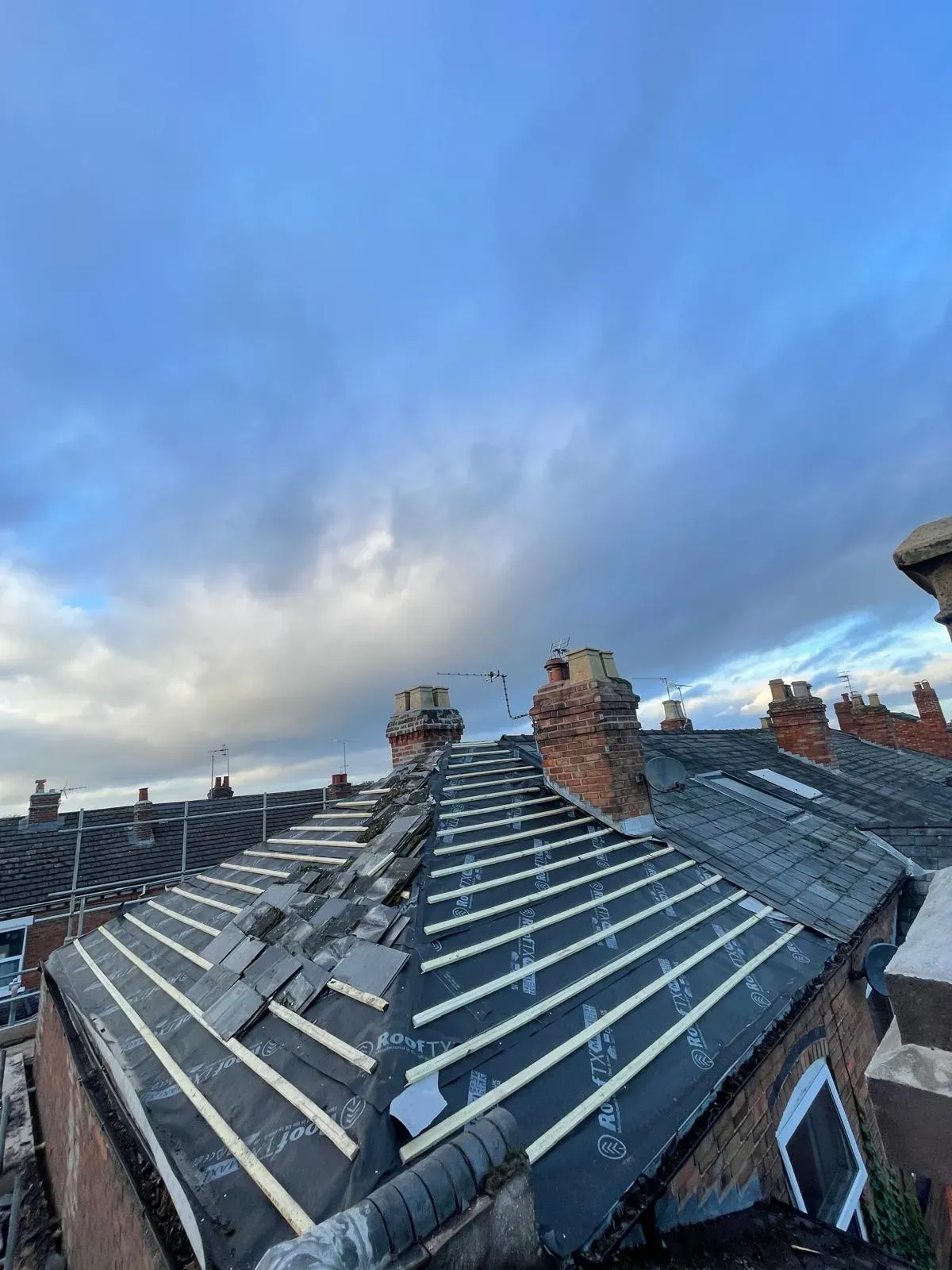 Pitched slate roof replacement showing breathable membrane and timber battens on a terraced house