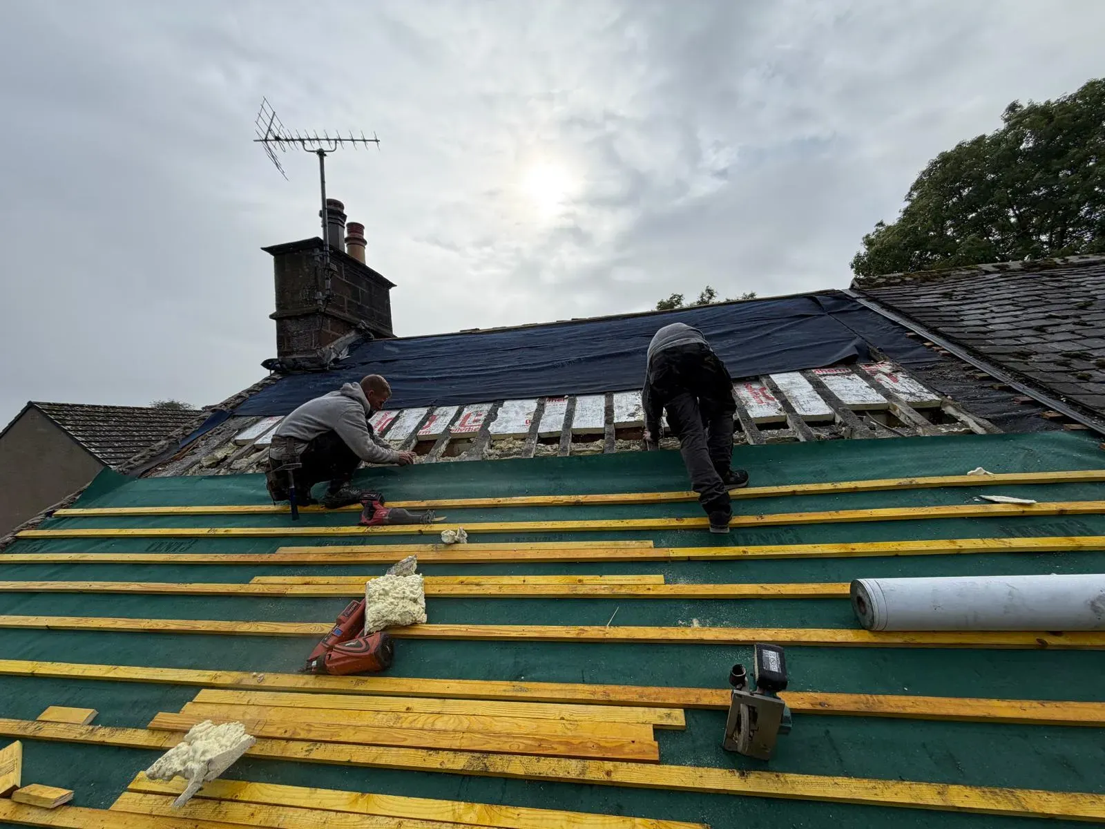 Roofers installing timber battens and breathable membrane during pitched roof installation in Worcester