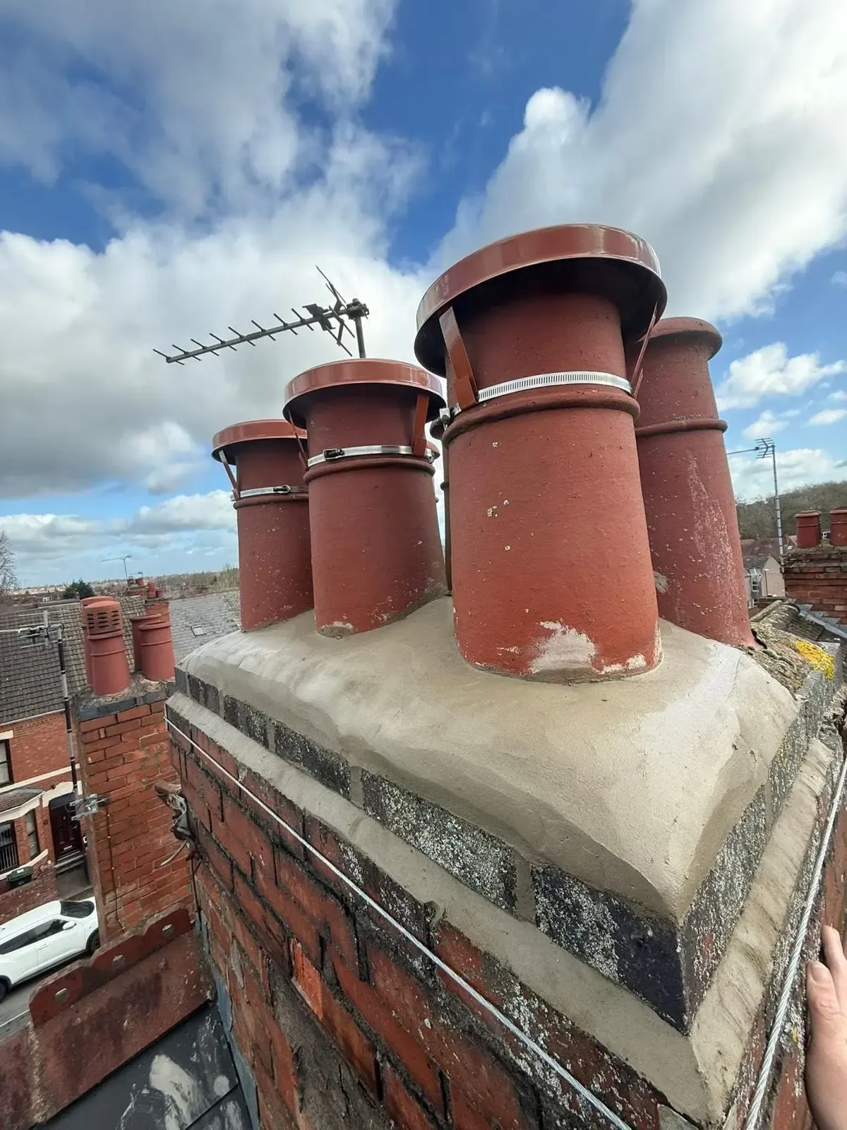 Chimney stack repointing and freshly flaunched terracotta pots with protective cowls installed by STORMPROOF ROOFING & REPAIRS LTD