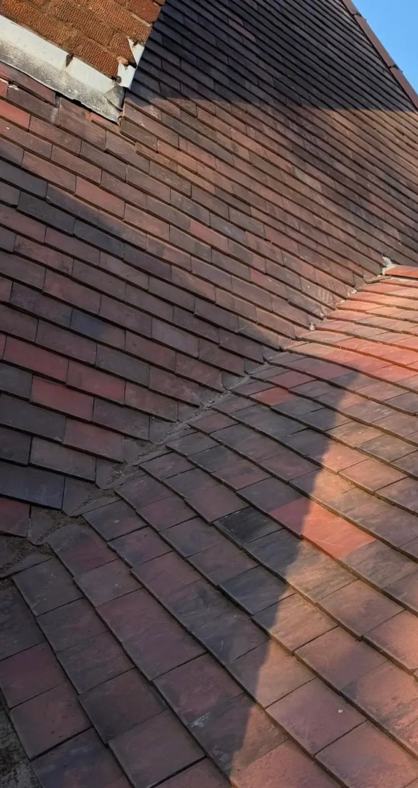 Pitched plain clay tile roof showing valley junction and roof tiles