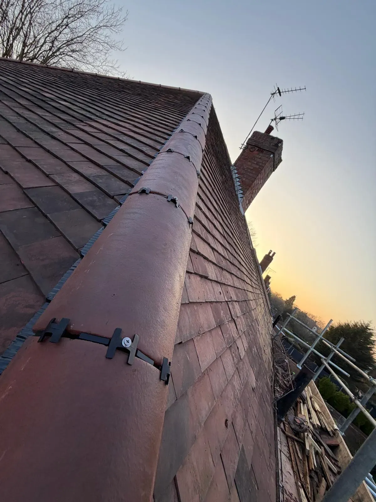 Mechanically fixed dry ridge system installation on a clay tile roof by Stormproof Roofing & Repairs Ltd