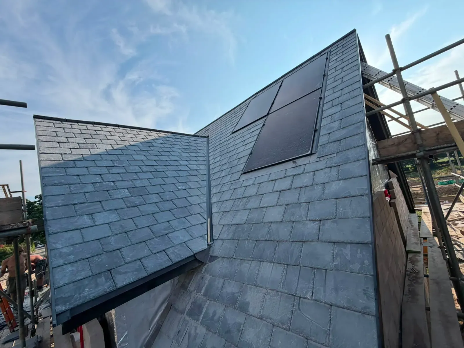 Newly installed natural slate pitched roof with roof valley flashing and integrated panels by STORMPROOF ROOFING & REPAIRS LTD