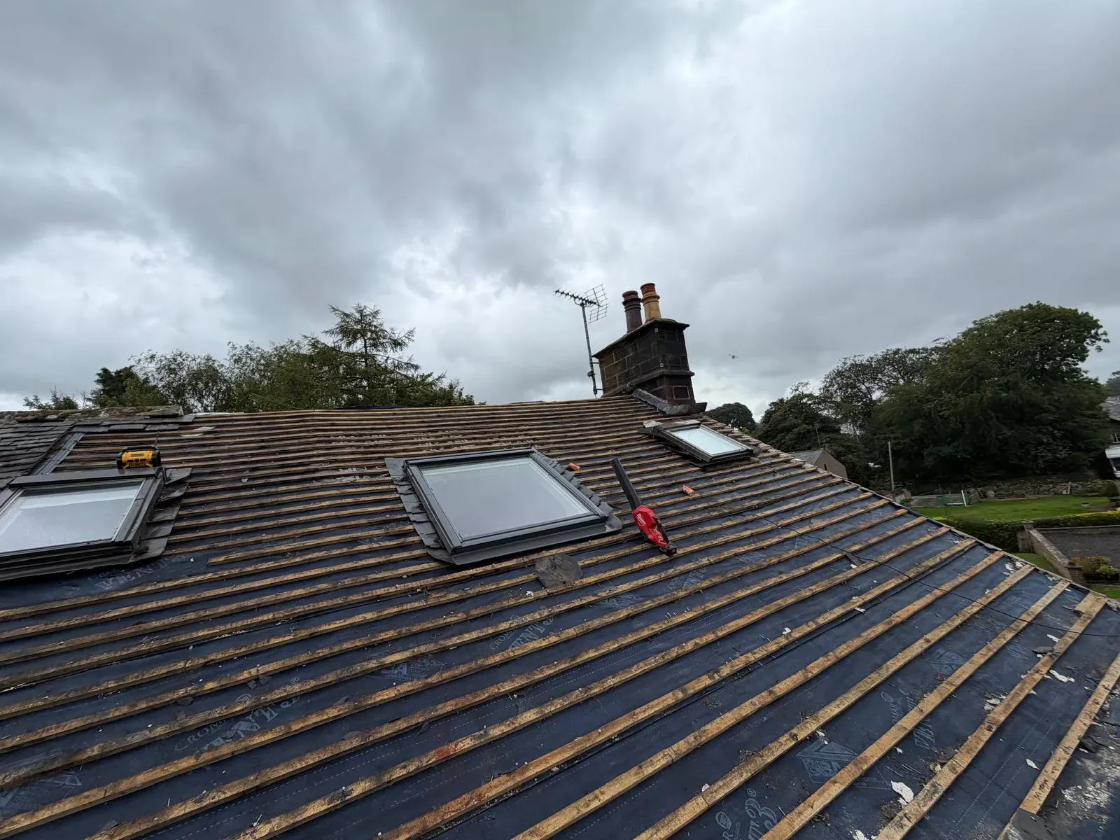 Pitched roof installation with breathable underlay, timber roofing battens, and skylights